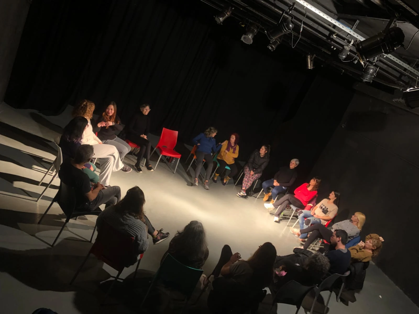 Participantes sentados en ronda en una sala teatral
